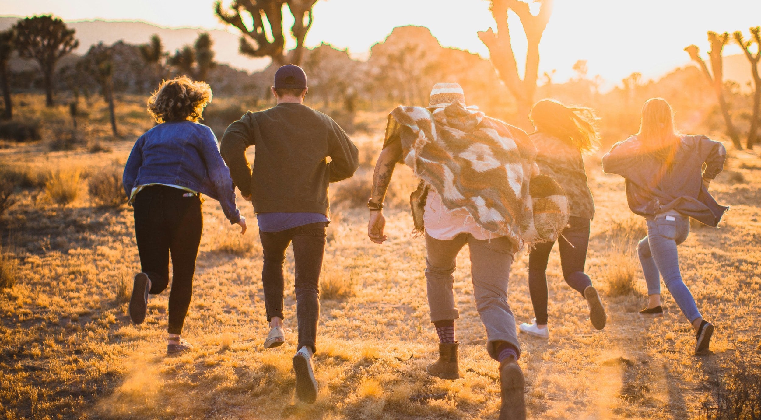 Group of people running in a field.